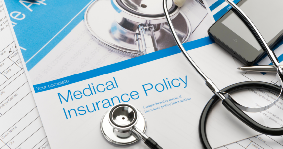 Photo of an health insurance document and a stethoscope